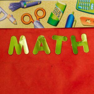 Bright educational banner featuring 'MATH' in green letters with school supplies illustration.